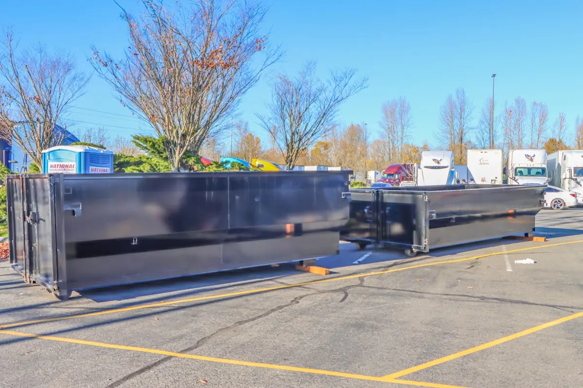 Professional dumpster rental service with roll-off container on residential driveway in Troutdale